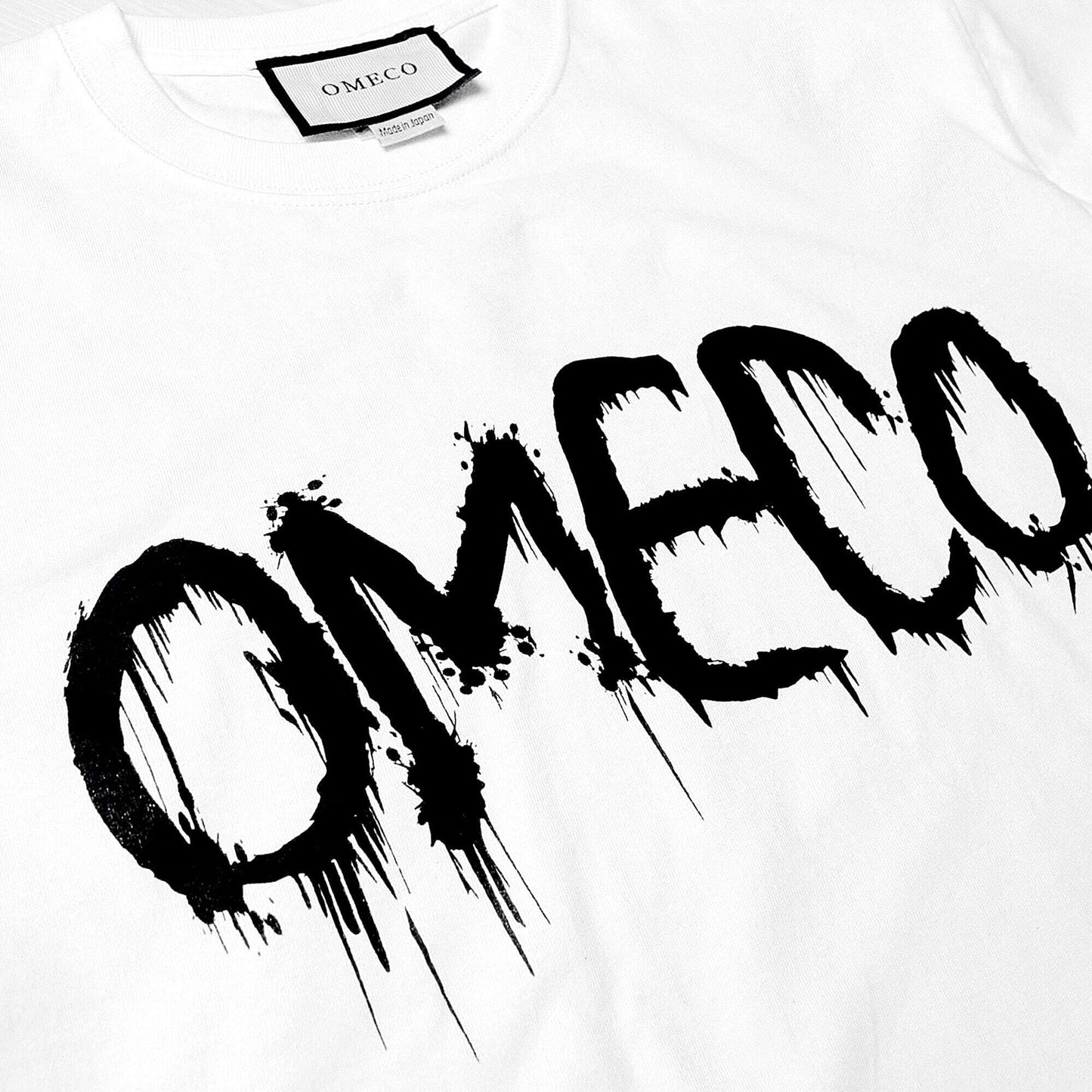 OMECO スプレーロゴ ロングスリーブ Tシャツ ブラック/ホワイト【ご注文から2~4週間前後での発送】